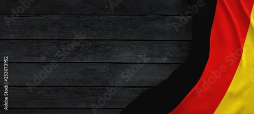 Cuadros en Lienzo Flag of Germany, fabric on dark wood.