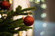 Red hanging Christmas decoration on fir Christmas tree with bokey in background