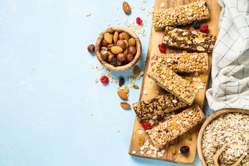 Wall Mural - Granola bar with nuts, fruits and berries on blue.