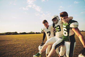 Wall Mural - American football players carrying an injured teammate off the f