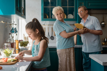 Wall Mural - Little girl cutting veggies