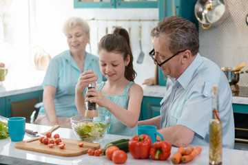 Wall Mural - Young girl preparing a salad