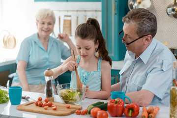 Wall Mural - Granddaughter cooking salad