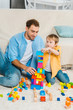 © LIGHTFIELD STUDIOS - father and adorable preschooler son playing with colorful building blocks at home