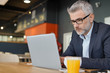 © goodluz - Businessman working in modern office cafeteria