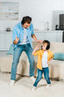 © LIGHTFIELD STUDIOS - father with preschooler son in headphones listening music and dancing at home
