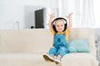 © LIGHTFIELD STUDIOS - adorable male toddler in headphones with hands in air listening music at home with copy space