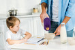 © LIGHTFIELD STUDIOS - father pouring cereal in bowl while preschooler son drawing during breakfast in morning