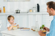 © LIGHTFIELD STUDIOS - father and preschooler son eating cereal during breakfast in kitchen