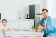 © LIGHTFIELD STUDIOS - happy father and preschooler son showing thumbs up and looking at camera during breakfast in kitchen