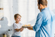 © LIGHTFIELD STUDIOS - father giving birthday cake to adorable preschooler son in kitchen