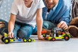 © LIGHTFIELD STUDIOS - cropped view of father and preschooler son playing with toy cars at home
