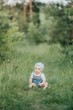 © Максим Галінский - A smiling child is enjoying the nature sitting on the grass