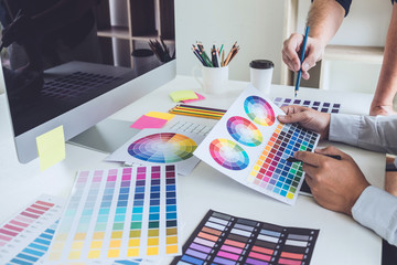 Poster - Two colleagues creative graphic designer working on color selection and drawing on graphics tablet at workplace