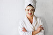 © lordn - Portrait of young woman with clay face mask on wearing bathrobe