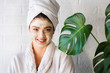 © lordn - Portrait of young woman with clay face mask on wearing bathrobe