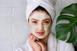 © lordn - Portrait of young woman with clay face mask on wearing bathrobe