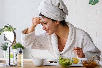 Young woman cleaning face with natural cosmetics. Clean fresh skin care.