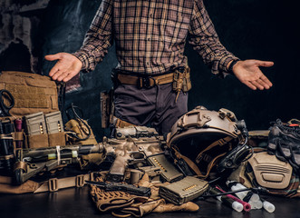 Wall Mural - Man in a checkered shirt showing his military uniform and equipment. Modern special forces equipment.