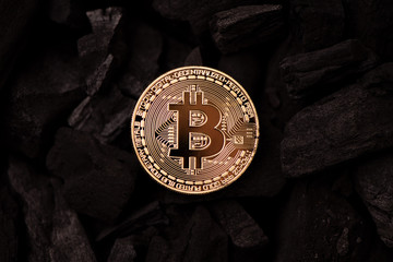 Bitcoin mining concept. Bitcoin cuurency on charcoal