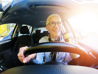 Wall Mural - Happy woman driving a car and drink coffee