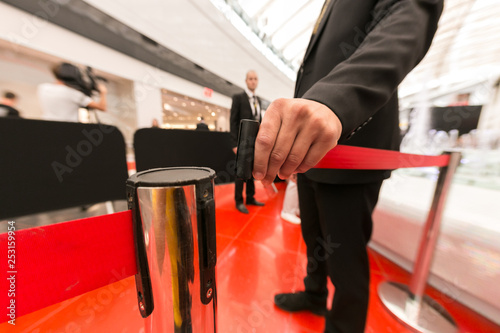 Cuadros en Lienzo Security hand fastens a red tape closing the passage