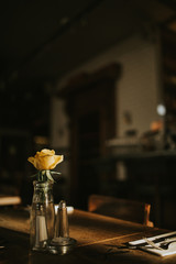 Wall Mural - A close up shot of a romantic dinner set up with glassware and a flower. Concept of restaurant business, catering and hospitality. Vertical image with free copy space for your text.