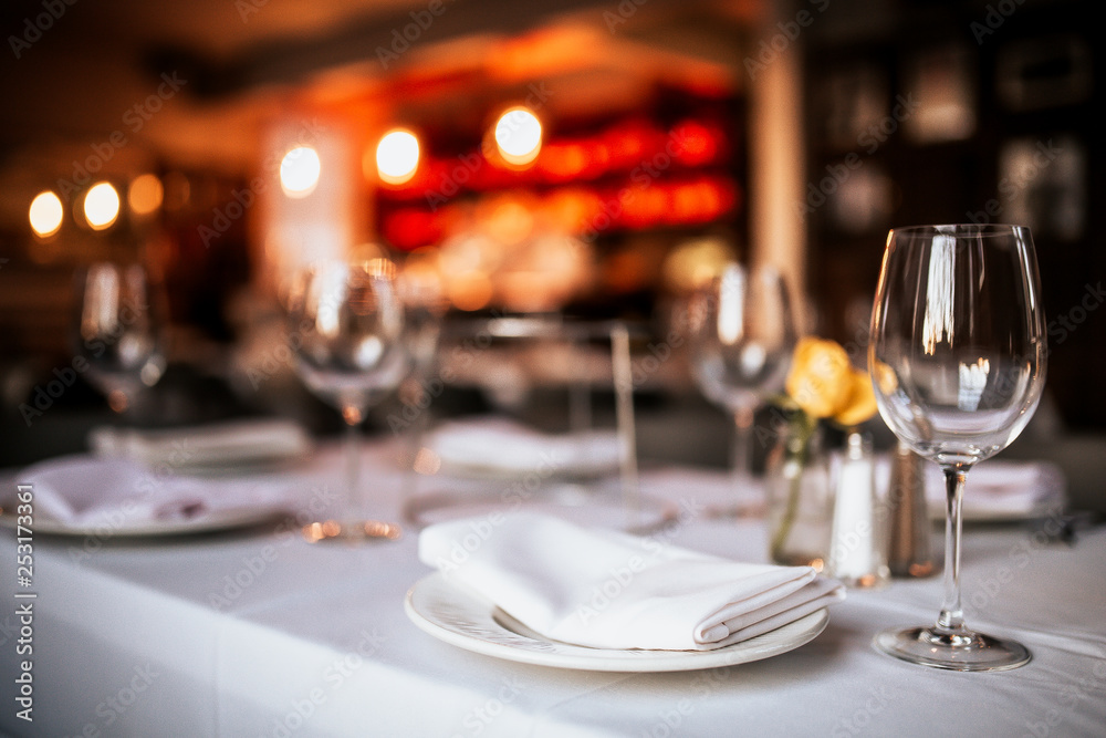 A close up shot of a restaurant table set up with tableware and wine glass. Concept of dining, hospitality and catering. Horizontal image with free space for text. - obrazy, fototapety, plakaty 