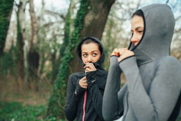 Wall Mural - Two young beautiful woman exercise in the forest