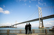 two gay men hugging at the bay bridge in san francisco
