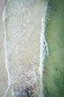 Drone waves crashing on beach tropical water birds eye view