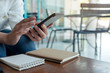 © Farknot Architect - Closeup image of a woman's hands holding , using and texting message from smart phone in cafe