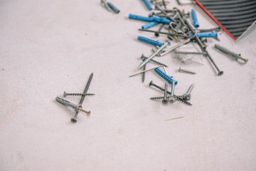 Screw on the floor. Scattered tool. Screws. Screws for fastening on the floor.