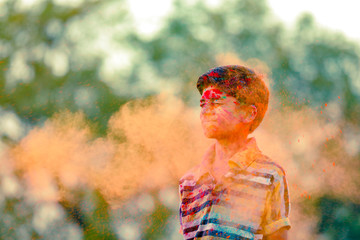 Indian child playing with the color in holi festival