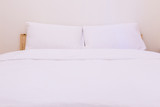 Fototapeta  - White pillow on bed and the clean blanket is good to sleep in the bedroom interior,fresh bed concept