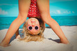cute little girl play on beach, kid upside down on sand