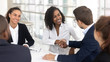 Diverse business partners shaking hands starting collaboration at group negotiations