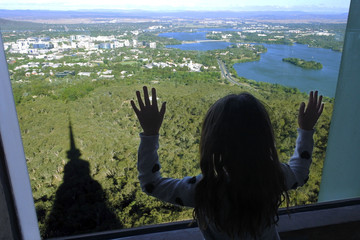 Young girl looking out of a window at Canberra the capital city of Australia