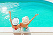 © Tijana - Two girls sitting by the pool, relaxing, having fun