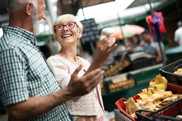 Portrait of beautiful elderly couple in market buing food