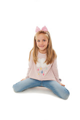 Wall Mural - Portrait of a adorable little girl sitting on knee, posing. Isolated on white background