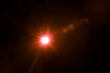 Abstract Lens Flare Red Light Over Black Background