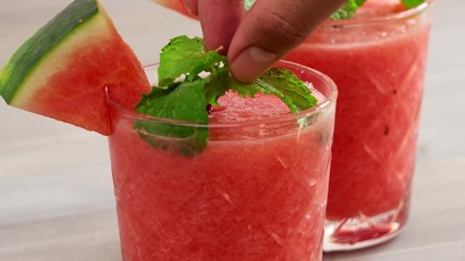 Wall Mural - Healthy homemade watermelon fruit smoothies in the glasses being garnished with peppermint leaves