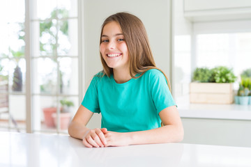 Beautiful young girl kid wearing green t-shirt with a happy and cool smile on face. Lucky person.