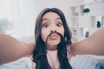 Poster - Close up photo cute beautiful she her little girl smart phone hands take selfies pretend boy guy make false moustache  wear home t-shirt pants comfortable apartments flat bright light colored room