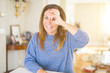 © Krakenimages.com - Beautiful middle age woman at home doing ok gesture with hand smiling, eye looking through fingers with happy face.