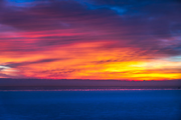 Wall Mural - gorgeous dramatic closeup sunrise photograph of the blue waters of lake michigan with orange, yellow