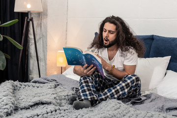 pleasant sleepy tired man seriously studying astrology