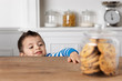 © Lisa Tichané - Young boy reaching at cookie jar on kitchen table