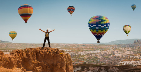 Wall Mural - successful sporty woman in Cappadocia with hot air balloons Concept of motion motivation inspiration